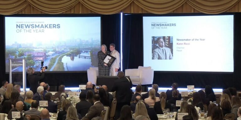 Kenn poses for a photo with Crain's interviewer on stage as he accepts the Newsmakers of the Year award